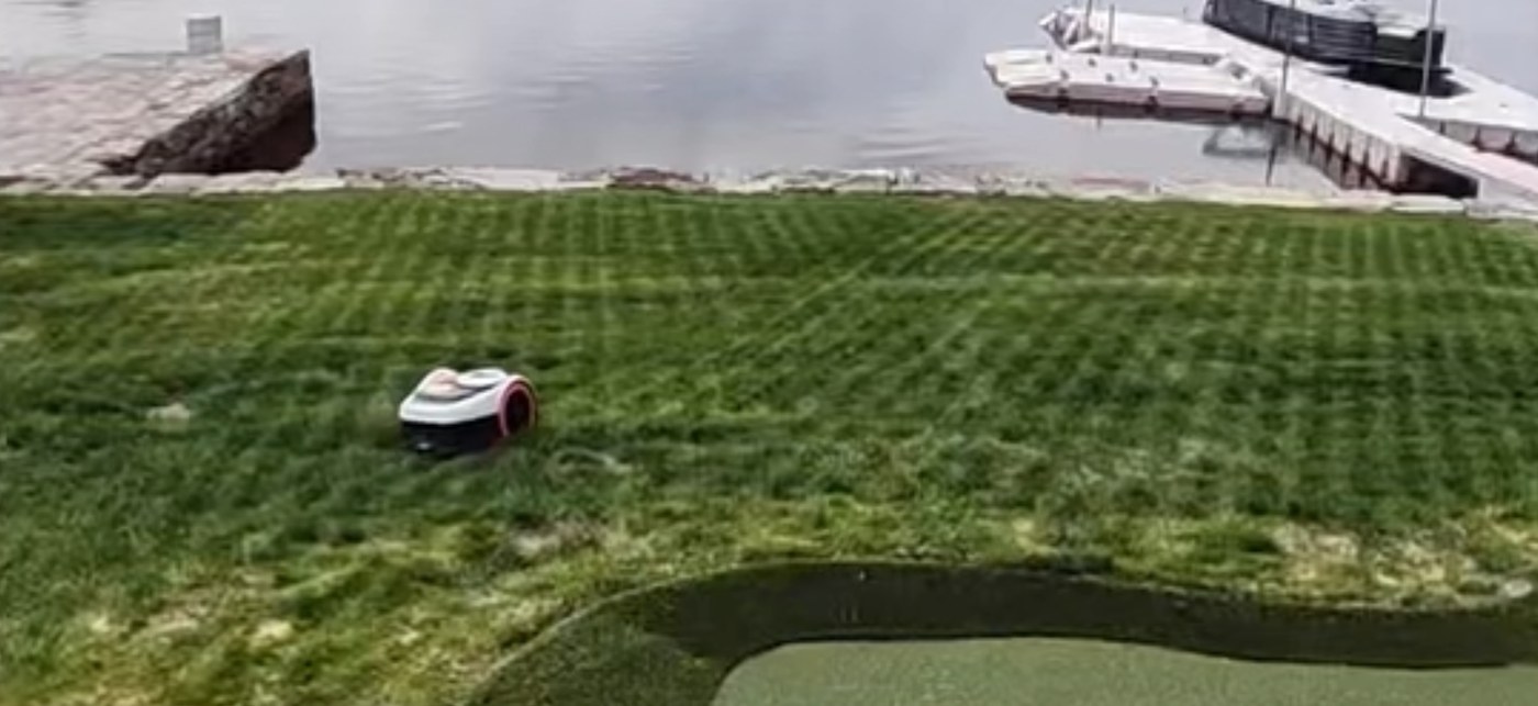 Husqvarna Automower running on a striped waterfront lawn in Connecticut